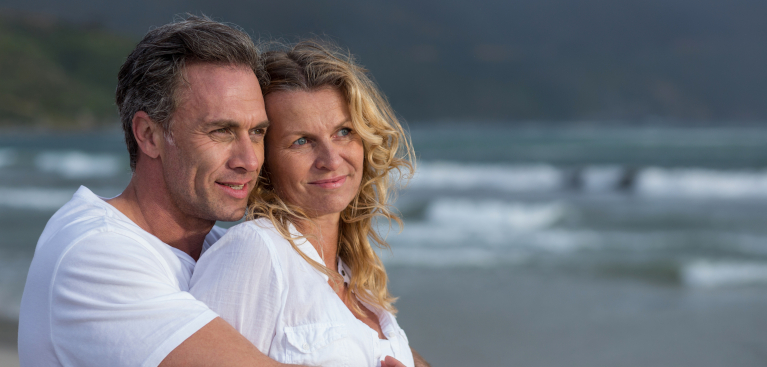 Mature couple embracing each other on the beach