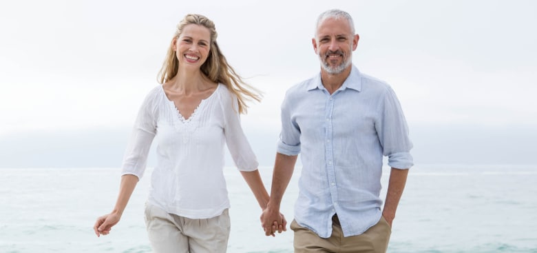 Happy couple walking by the sea